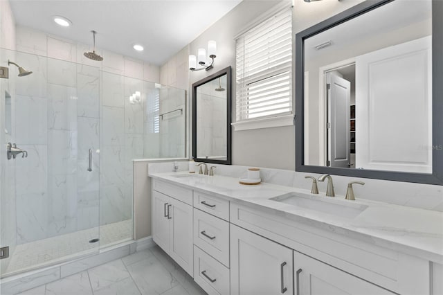 bathroom featuring a shower with door and vanity