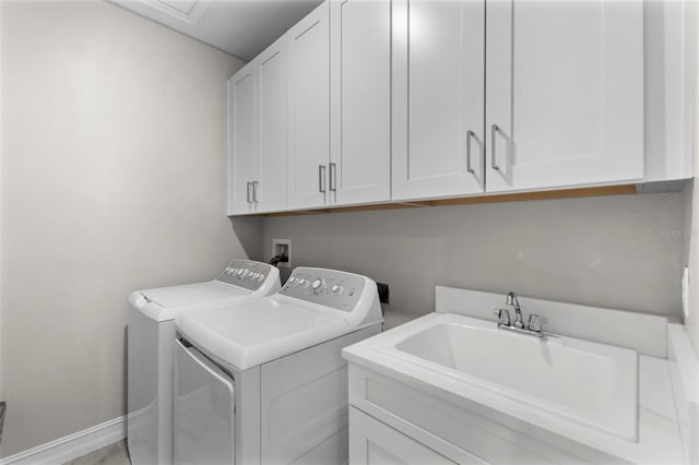 washroom with sink, washing machine and dryer, and cabinets