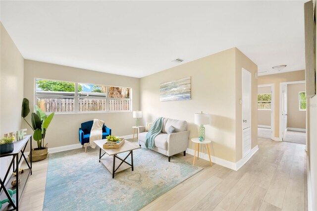 sitting room featuring visible vents, light wood-style flooring, and baseboards