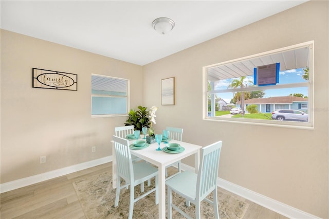 dining room with light wood-style flooring and baseboards