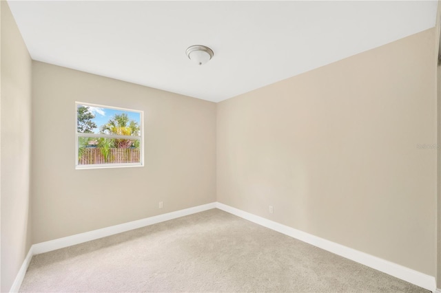 unfurnished room with carpet floors and baseboards