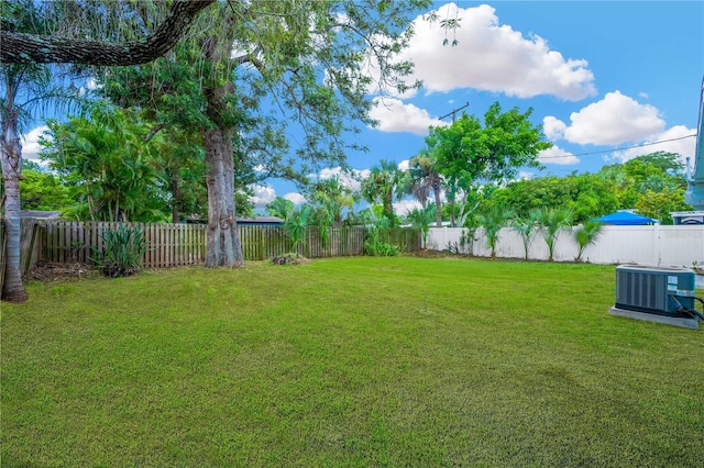 view of yard with central air condition unit and a fenced backyard