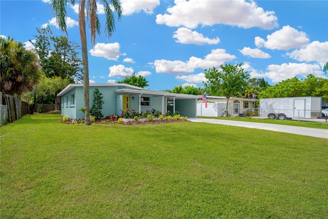 view of front facade with a porch, a front yard, fence, a carport, and driveway