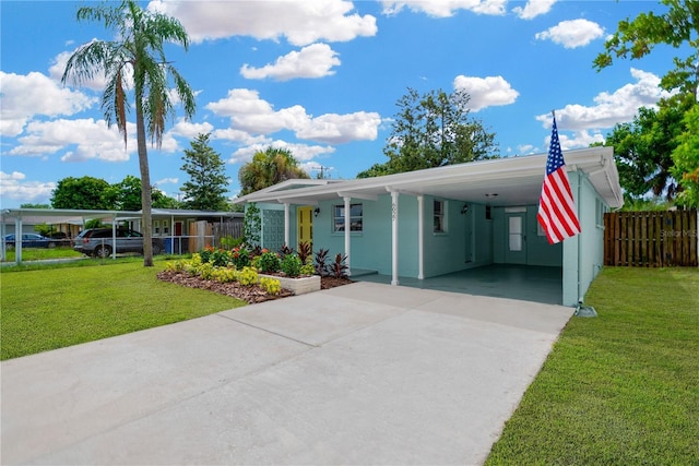 view of front of property featuring an attached carport, fence, driveway, and a front yard