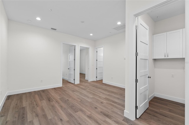 spare room with light wood-type flooring, baseboards, and visible vents