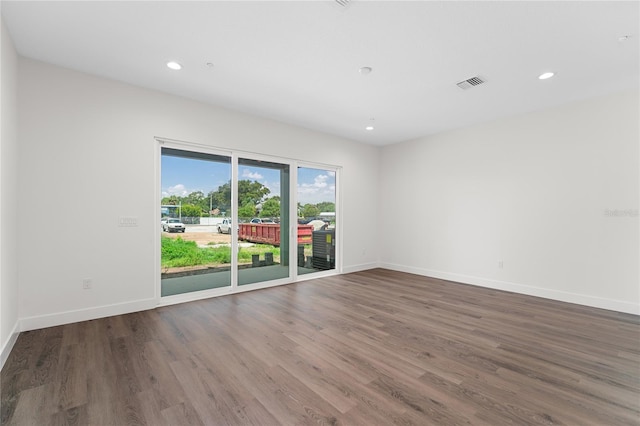 spare room with baseboards, visible vents, wood finished floors, and recessed lighting