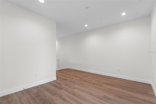 unfurnished room featuring recessed lighting, baseboards, and wood finished floors