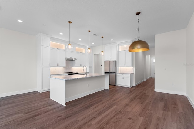 kitchen featuring dark wood-style flooring, a sink, freestanding refrigerator, and white cabinetry