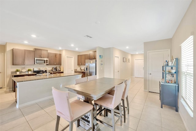 dining area featuring plenty of natural light, sink, and light tile patterned floors