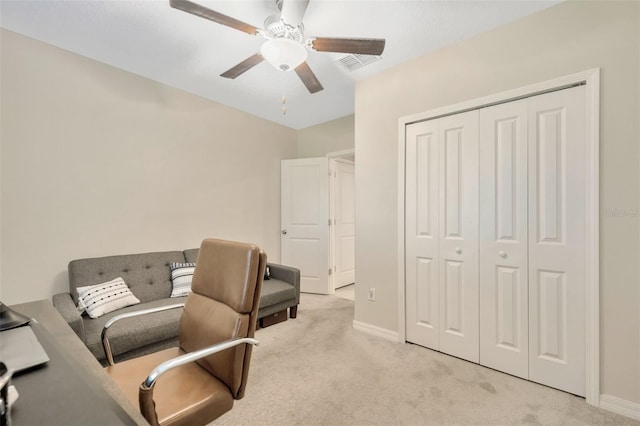 carpeted office space with ceiling fan