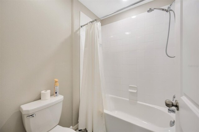 bathroom with shower / tub combo with curtain and toilet