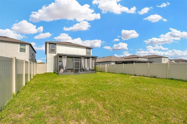 rear view of property with a yard and a sunroom