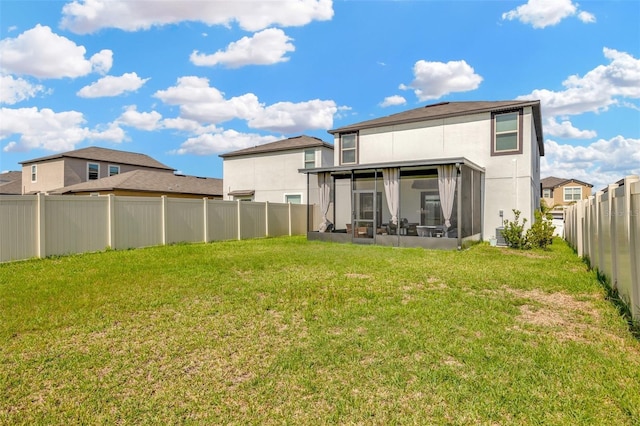 back of property featuring a yard and a sunroom