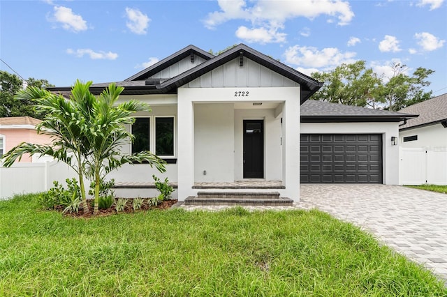 view of front of home with a garage and a front lawn