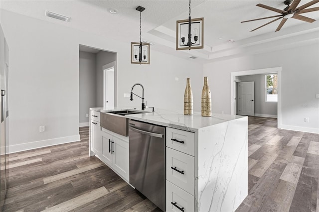 kitchen with white cabinets, hanging light fixtures, light stone countertops, a tray ceiling, and stainless steel dishwasher