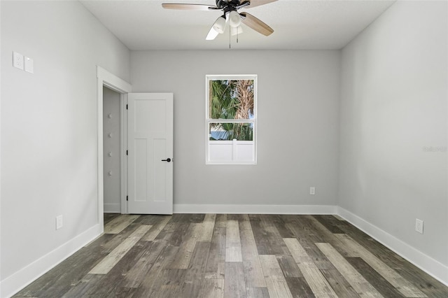 unfurnished room with dark wood-style floors, ceiling fan, and baseboards