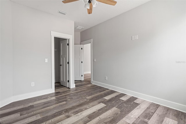 unfurnished bedroom featuring baseboards, visible vents, a ceiling fan, dark wood-style floors, and a closet