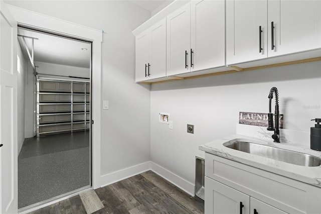 laundry area featuring hookup for a washing machine, a sink, baseboards, cabinet space, and electric dryer hookup