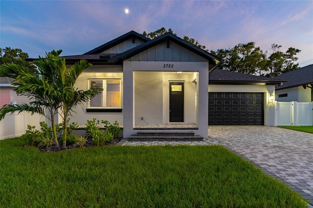 view of front facade with an attached garage, entry steps, decorative driveway, and a front yard