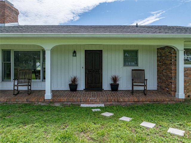 doorway to property featuring a yard and a porch