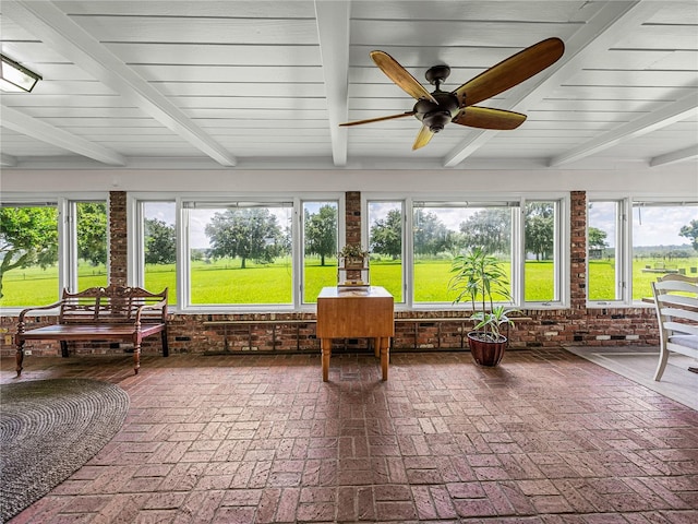 sunroom featuring beam ceiling, a healthy amount of sunlight, and ceiling fan