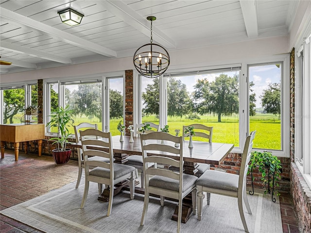 sunroom / solarium with beam ceiling and a chandelier