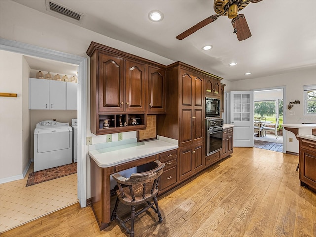 kitchen with dark brown cabinetry, black microwave, washing machine and clothes dryer, wall oven, and light wood-type flooring