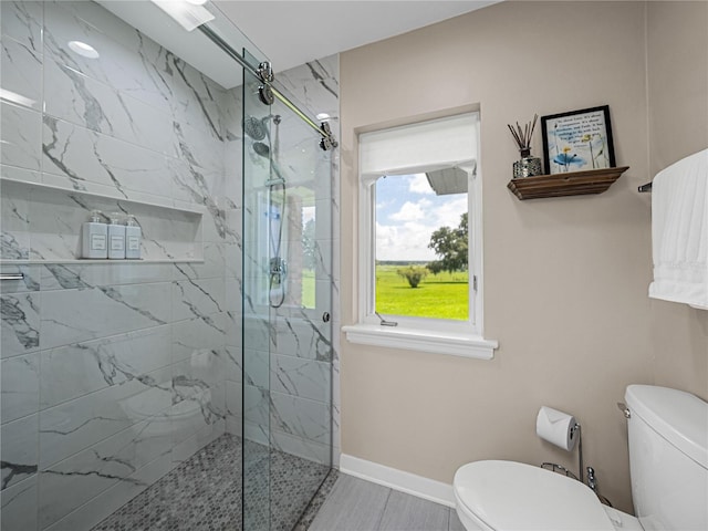 bathroom featuring toilet and a shower with shower door