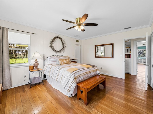 bedroom featuring ceiling fan, wood-type flooring, and ornamental molding