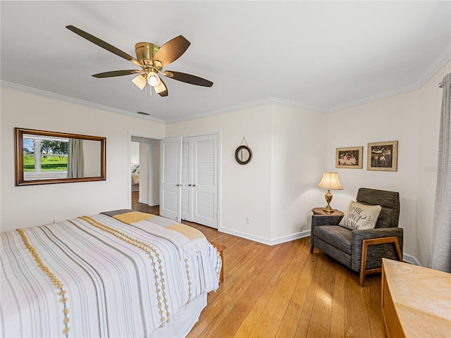 bedroom featuring ceiling fan, ornamental molding, a closet, and light hardwood / wood-style flooring