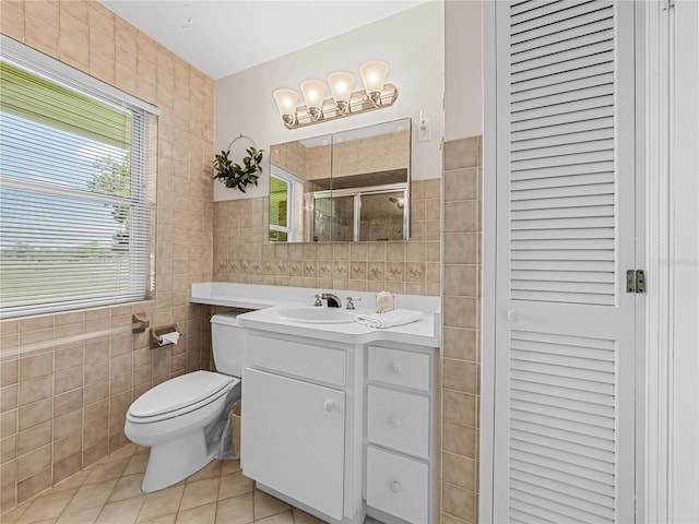 bathroom with tile patterned flooring, vanity, tile walls, and toilet