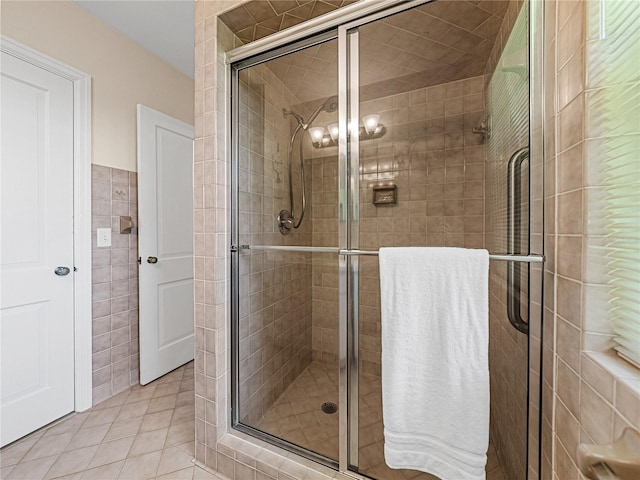 bathroom featuring tile walls, tile patterned floors, and an enclosed shower