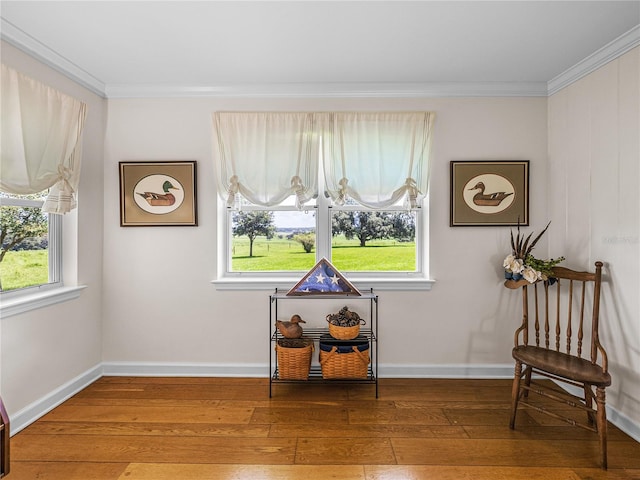 living area featuring hardwood / wood-style floors, ornamental molding, and plenty of natural light