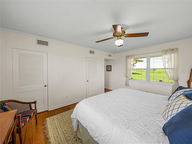 bedroom with ceiling fan, hardwood / wood-style floors, a closet, and ornamental molding