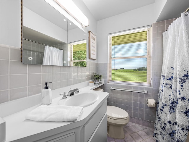 bathroom featuring toilet, vanity, tile patterned flooring, tile walls, and a shower with curtain