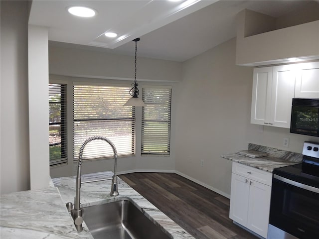 kitchen with dark wood-type flooring, hanging light fixtures, light stone counters, stainless steel electric stove, and white cabinets