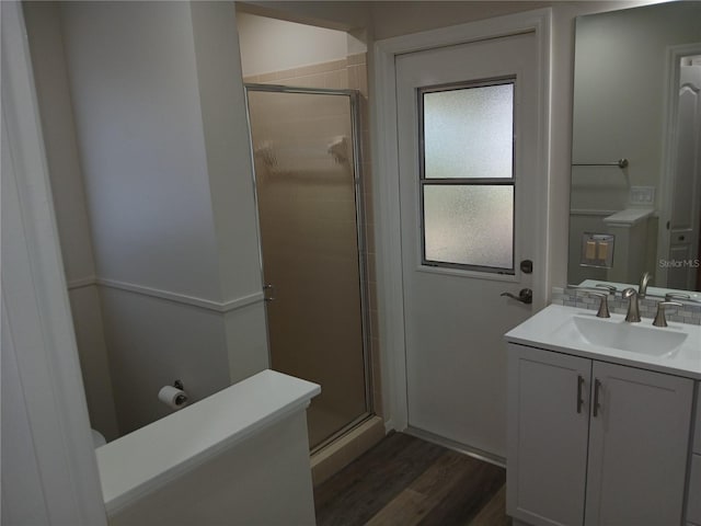 bathroom with vanity, wood-type flooring, and a shower with door