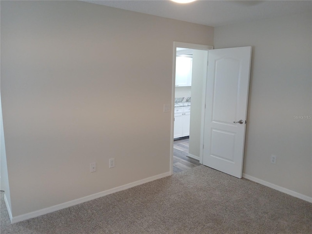 spare room featuring light colored carpet