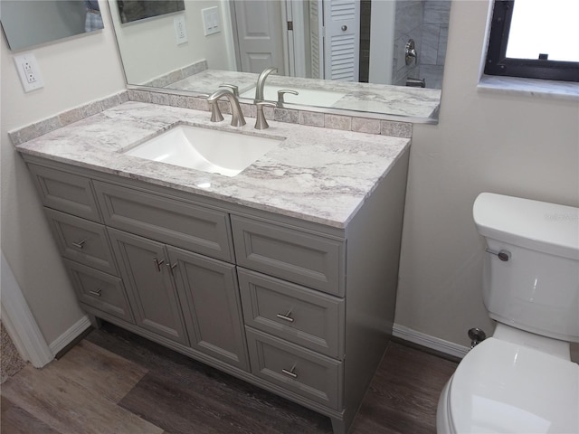 bathroom with hardwood / wood-style flooring, vanity, and toilet