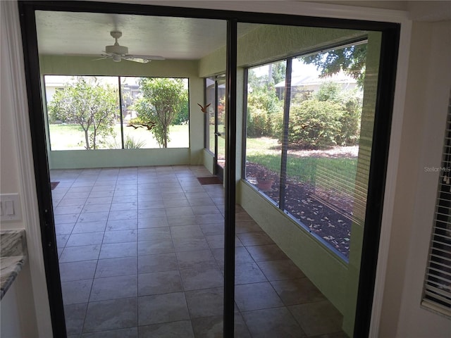 unfurnished sunroom featuring ceiling fan