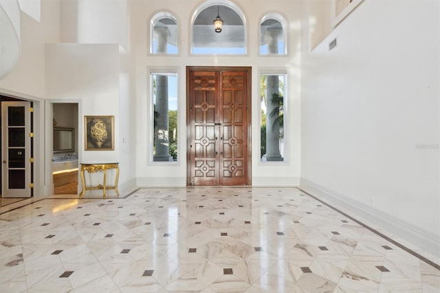 entryway featuring a high ceiling, visible vents, and baseboards