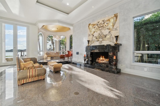 interior space featuring plenty of natural light, granite finish floor, baseboards, and ornamental molding