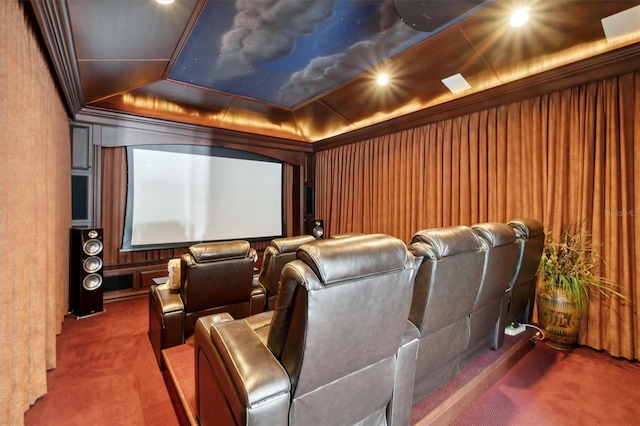 cinema room featuring a tray ceiling, ornamental molding, and carpet