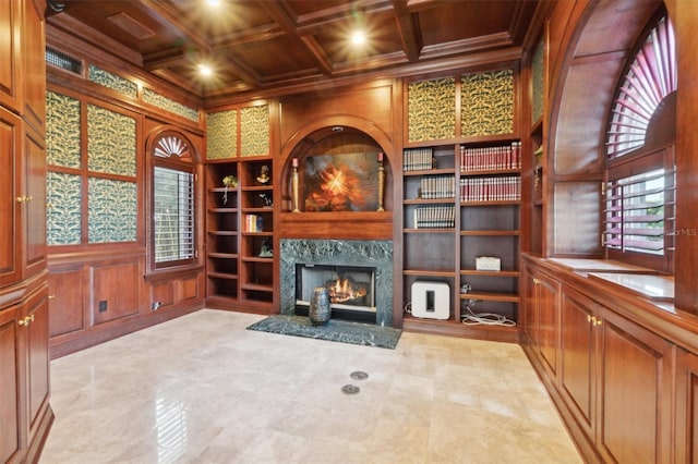 living room with built in features, coffered ceiling, wooden ceiling, ornamental molding, and wood walls