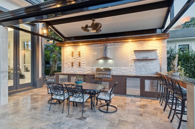 view of patio with french doors, area for grilling, grilling area, outdoor wet bar, and outdoor dining space