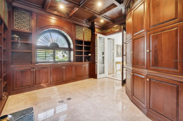 interior space featuring built in shelves, coffered ceiling, marble finish floor, ornamental molding, and beam ceiling