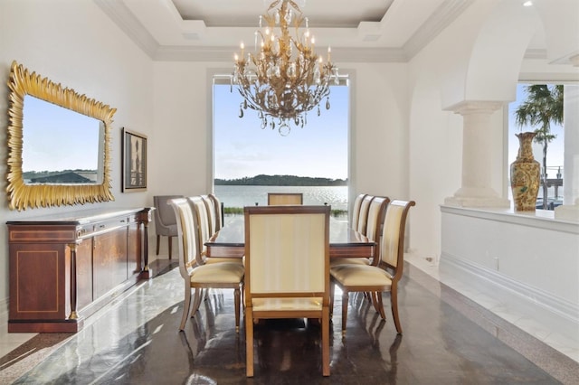 dining room featuring arched walkways, a notable chandelier, ornamental molding, a tray ceiling, and ornate columns