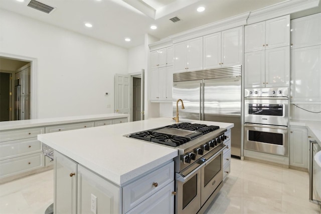 kitchen featuring white cabinetry, visible vents, stainless steel appliances, and a center island