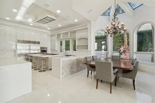 kitchen featuring a kitchen island, a kitchen breakfast bar, stainless steel appliances, light countertops, and white cabinetry