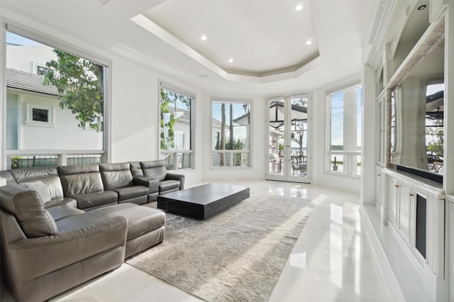 living room with recessed lighting, a raised ceiling, and french doors